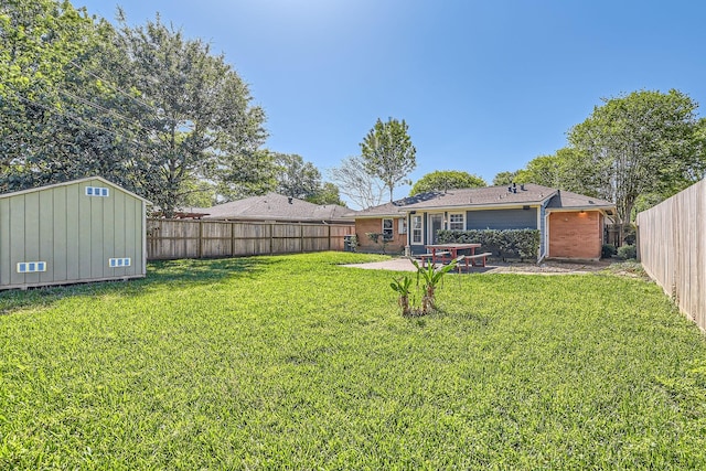 view of yard featuring an outbuilding, a shed, a fenced backyard, and a patio area