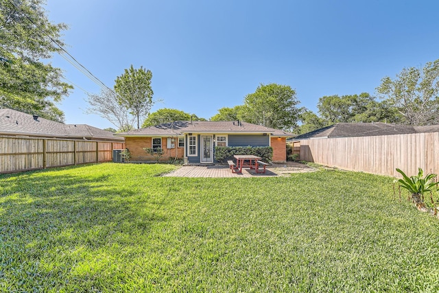rear view of house with cooling unit, a yard, a fenced backyard, and a patio area