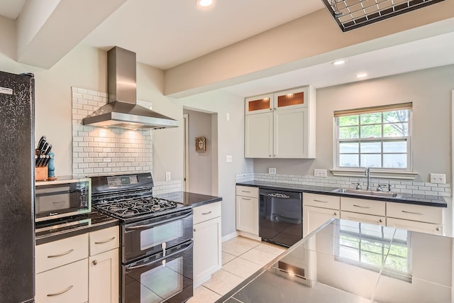 kitchen featuring wall chimney range hood, light tile patterned flooring, black appliances, visible vents, and a sink