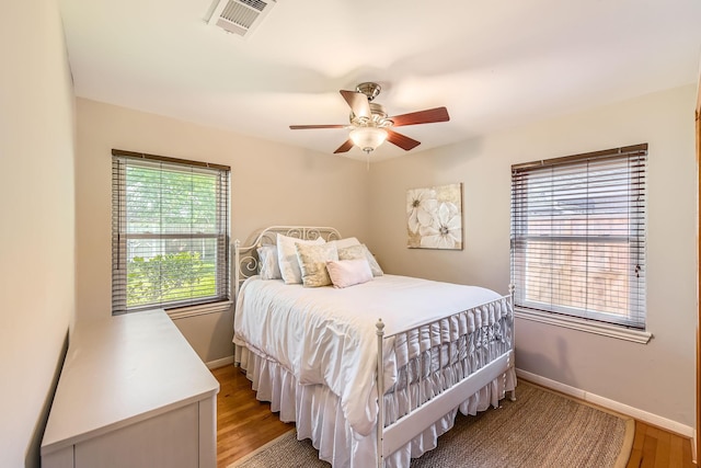 bedroom featuring visible vents, baseboards, light wood-type flooring, and a ceiling fan