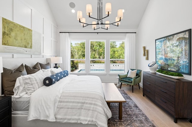 bedroom with a chandelier, high vaulted ceiling, and light wood finished floors