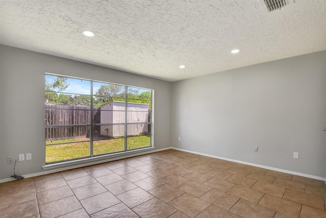 6902 Desert Rose Ln, Houston, TX 77086 - spare room featuring a textured ceiling, recessed lighting, and baseboards