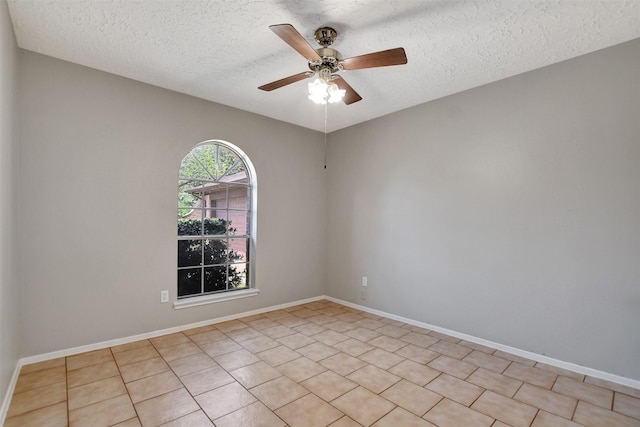6902 Desert Rose Ln, Houston, TX 77086 - spare room featuring a textured ceiling, a ceiling fan, baseboards, and light tile patterned floors