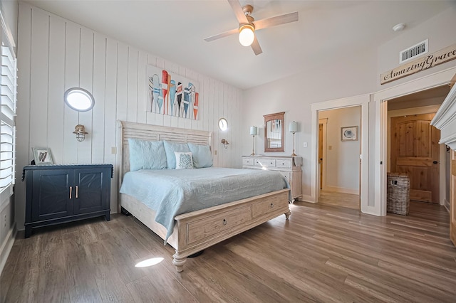 bedroom featuring visible vents, ceiling fan, baseboards, and wood finished floors