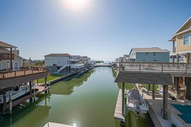 view of dock with a water view, a residential view, and boat lift