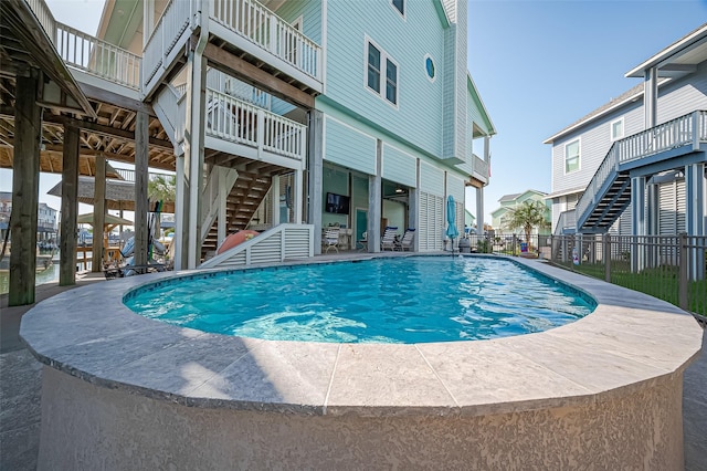 view of pool featuring a fenced in pool, a patio area, stairway, and fence