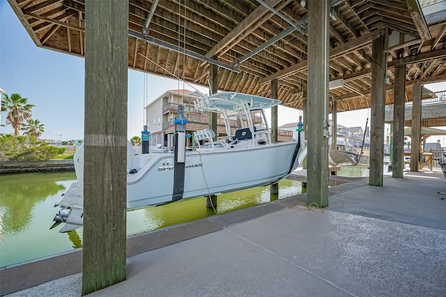 view of patio / terrace featuring a water view, boat lift, and a dock