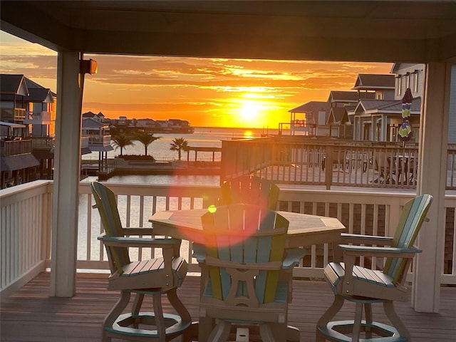 balcony at dusk with a water view and a residential view