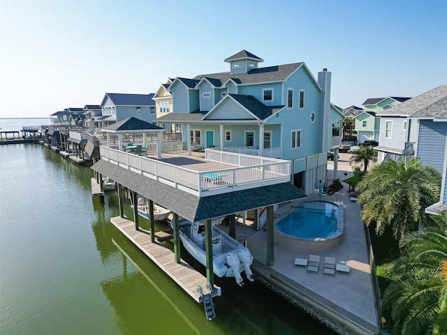 rear view of house featuring a water view, a community pool, a residential view, and boat lift