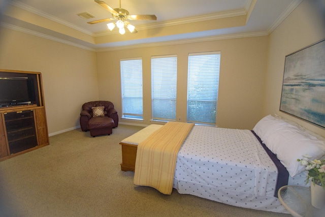 bedroom featuring ornamental molding, light carpet, and a tray ceiling