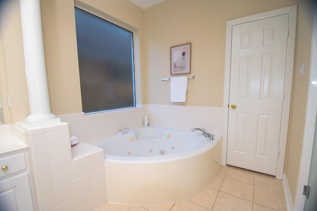 bathroom featuring decorative columns, tile patterned flooring, and a jetted tub