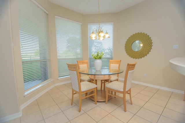 dining area with a chandelier, baseboards, and light tile patterned flooring
