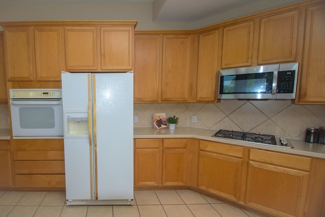 kitchen with appliances with stainless steel finishes, decorative backsplash, light countertops, and light tile patterned floors