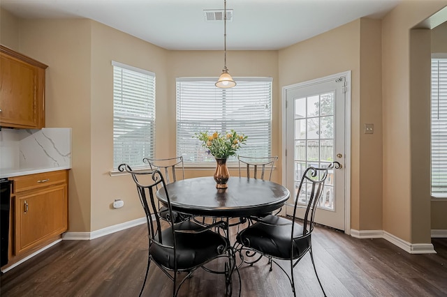 dining space with dark wood-type flooring, baseboards, and visible vents