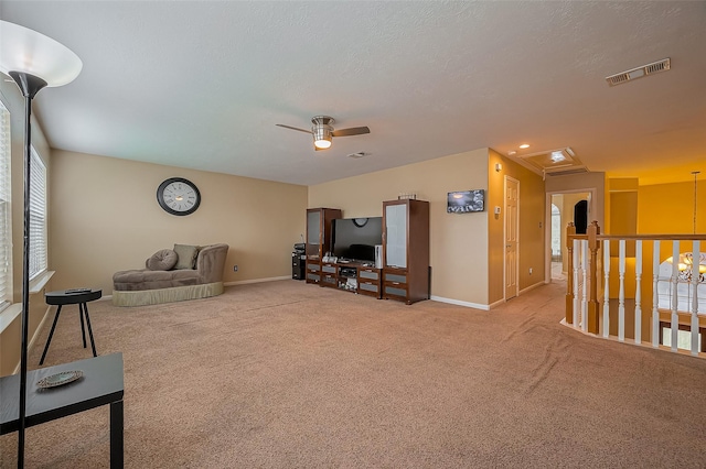 living area with carpet floors, a ceiling fan, baseboards, and visible vents