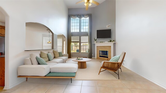 16410 Bluff Springs Dr, Houston, TX 77095 - living area with a towering ceiling, tile patterned floors, a ceiling fan, arched walkways, and a tile fireplace