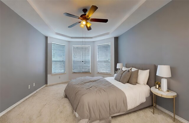 16410 Bluff Springs Dr, Houston, TX 77095 - bedroom with baseboards, a raised ceiling, light colored carpet, and a ceiling fan
