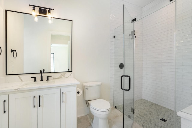 bathroom featuring toilet, a stall shower, and vanity