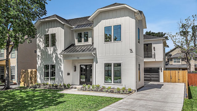 modern farmhouse style home with board and batten siding, a standing seam roof, metal roof, a garage, and concrete driveway