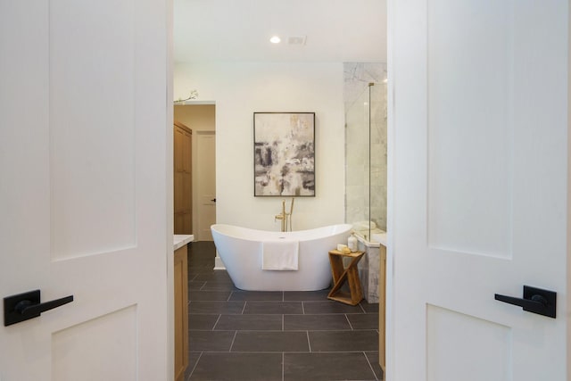 full bath with a stall shower, a freestanding tub, and tile patterned floors