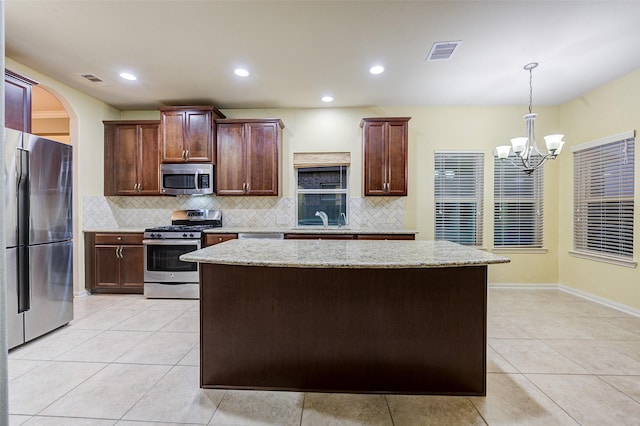 8719 Seguin Cove Ln, Richmond, TX 77407 - kitchen with visible vents, a sink, appliances with stainless steel finishes, a chandelier, and a kitchen island