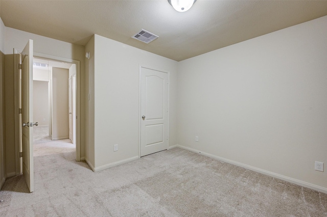 8719 Seguin Cove Ln, Richmond, TX 77407 - unfurnished bedroom featuring visible vents, baseboards, and light carpet