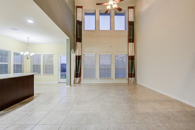8719 Seguin Cove Ln, Richmond, TX 77407 - unfurnished living room featuring visible vents, baseboards, light tile patterned floors, and ceiling fan with notable chandelier