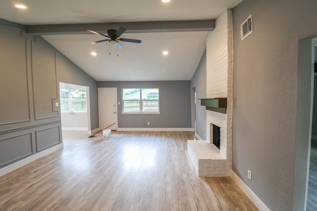 unfurnished living room with vaulted ceiling with beams, a fireplace, a ceiling fan, and visible vents