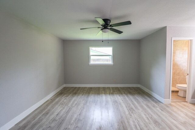 empty room featuring a ceiling fan, baseboards, and wood finished floors
