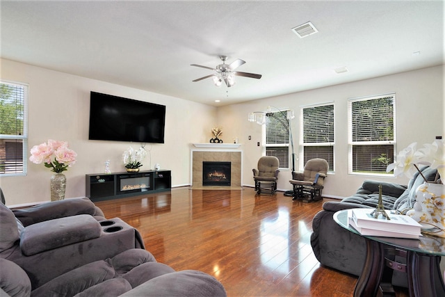 5318 El Tigre Ln, Baytown, TX 77521 - living room featuring wood finished floors, a tiled fireplace, a ceiling fan, and visible vents