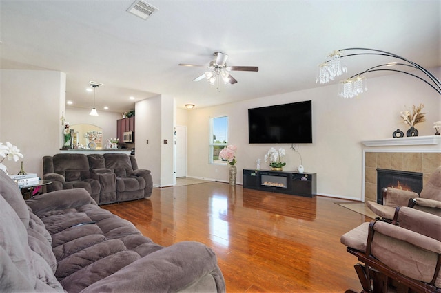 5318 El Tigre Ln, Baytown, TX 77521 - living area with ceiling fan, visible vents, wood finished floors, a tiled fireplace, and baseboards