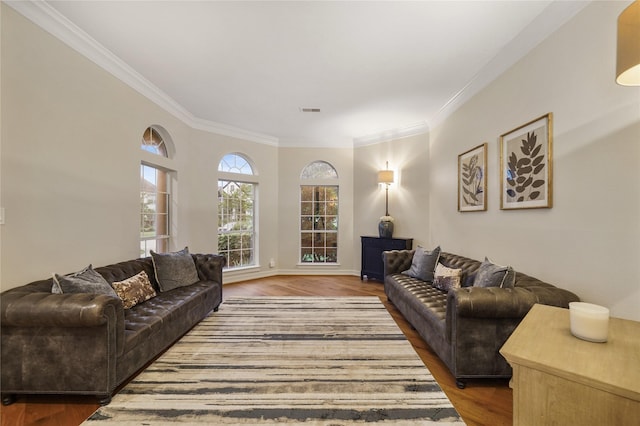 living area featuring crown molding, wood finished floors, baseboards, and visible vents