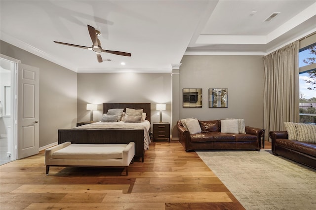 bedroom with light wood finished floors, visible vents, baseboards, and ornamental molding
