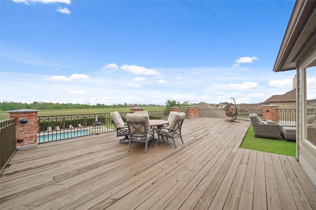 wooden terrace featuring a fenced in pool and outdoor dining area