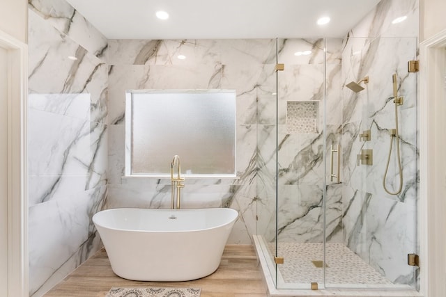 full bathroom with a marble finish shower, recessed lighting, a soaking tub, and wood finished floors