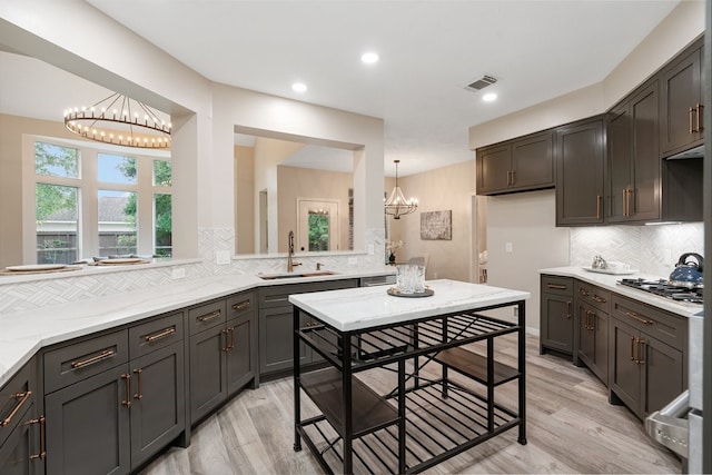 kitchen featuring an inviting chandelier, a sink, visible vents, and stainless steel gas stovetop