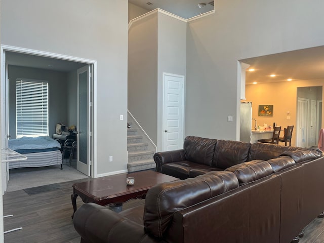 10427 Cecilia Star Ln, Richmond, TX 77406 - living area with dark wood-style flooring, a towering ceiling, baseboards, and stairs