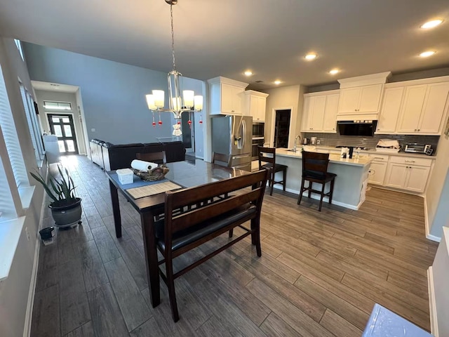 10427 Cecilia Star Ln, Richmond, TX 77406 - dining area featuring a toaster, an inviting chandelier, dark wood-style floors, and recessed lighting
