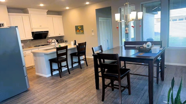 10427 Cecilia Star Ln, Richmond, TX 77406 - dining area featuring dark wood-style flooring, a notable chandelier, baseboards, and recessed lighting