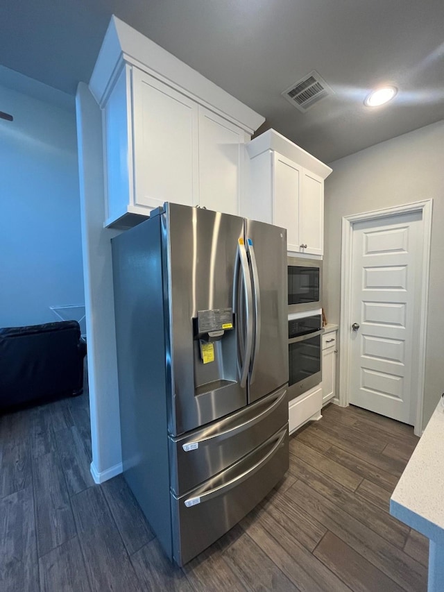 10427 Cecilia Star Ln, Richmond, TX 77406 - kitchen with light stone counters, white cabinetry, visible vents, dark wood finished floors, and appliances with stainless steel finishes