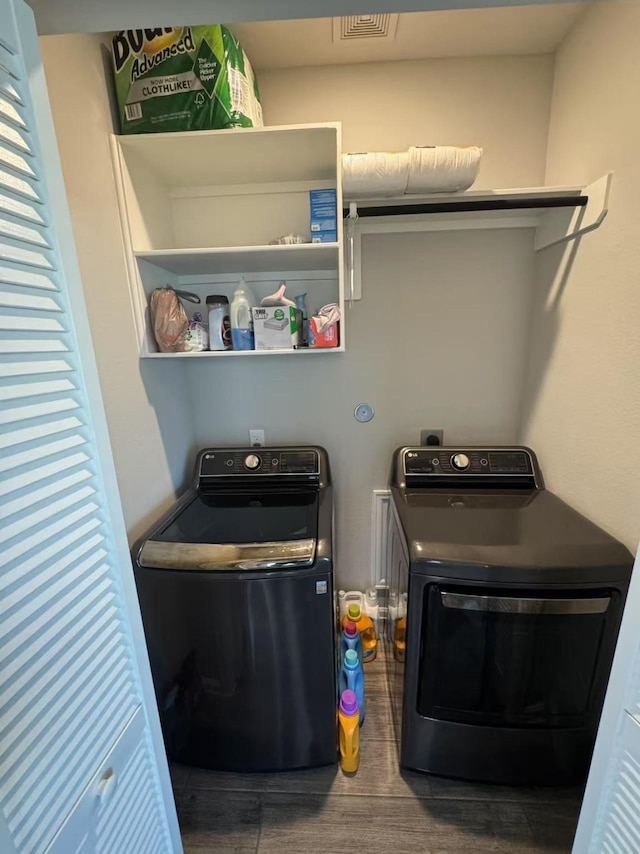10427 Cecilia Star Ln, Richmond, TX 77406 - clothes washing area featuring washer and dryer and wood finished floors