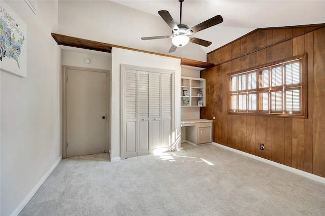 18614 Prince William Ln, Houston, TX 77058 - unfurnished bedroom featuring lofted ceiling, light carpet, wooden walls, and built in desk