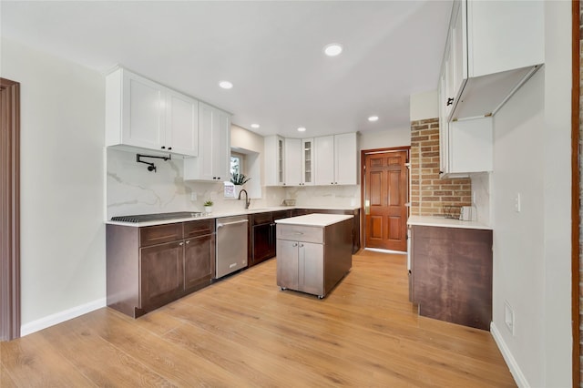 18614 Prince William Ln, Houston, TX 77058 - kitchen featuring stainless steel dishwasher, tasteful backsplash, a sink, glass insert cabinets, and light wood finished floors