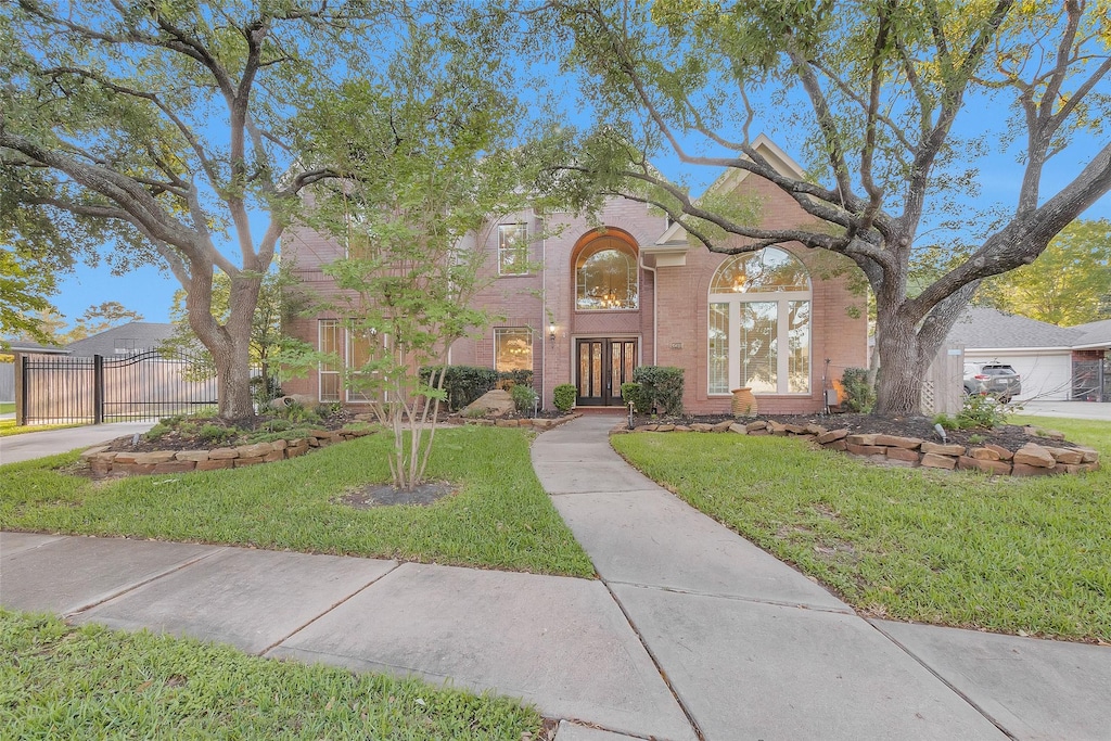 20414 Gentle Mist Ln, Cypress, TX 77433 - view of front facade featuring brick siding, a front lawn, fence, and a gate