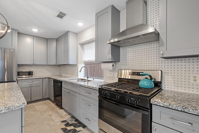 kitchen featuring a sink, wall chimney exhaust hood, black appliances, and gray cabinetry