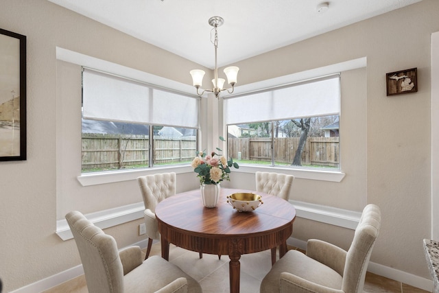 dining room featuring an inviting chandelier, baseboards, and plenty of natural light