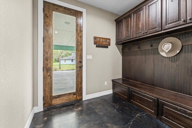 mudroom with baseboards and concrete floors