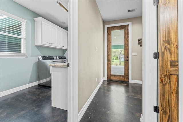 interior space featuring visible vents, a textured wall, washer and dryer, baseboards, and concrete floors