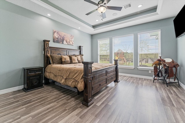 bedroom featuring baseboards, wood finished floors, and visible vents