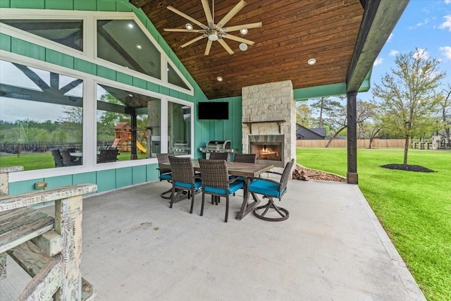 view of patio / terrace featuring a ceiling fan, an outdoor stone fireplace, fence, outdoor dining space, and a grill